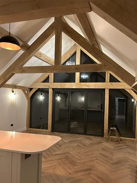 Interior oak frame with exposed trusses and a glazed gable end
