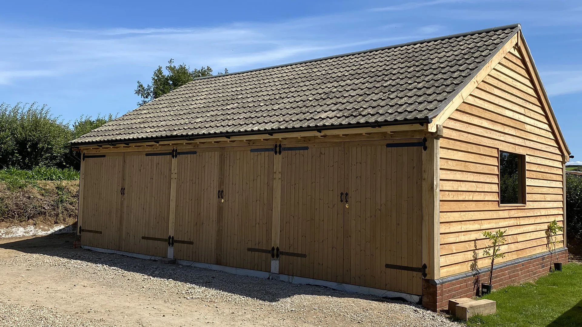 Oak framed garage with cedar cladding and a tiled roof